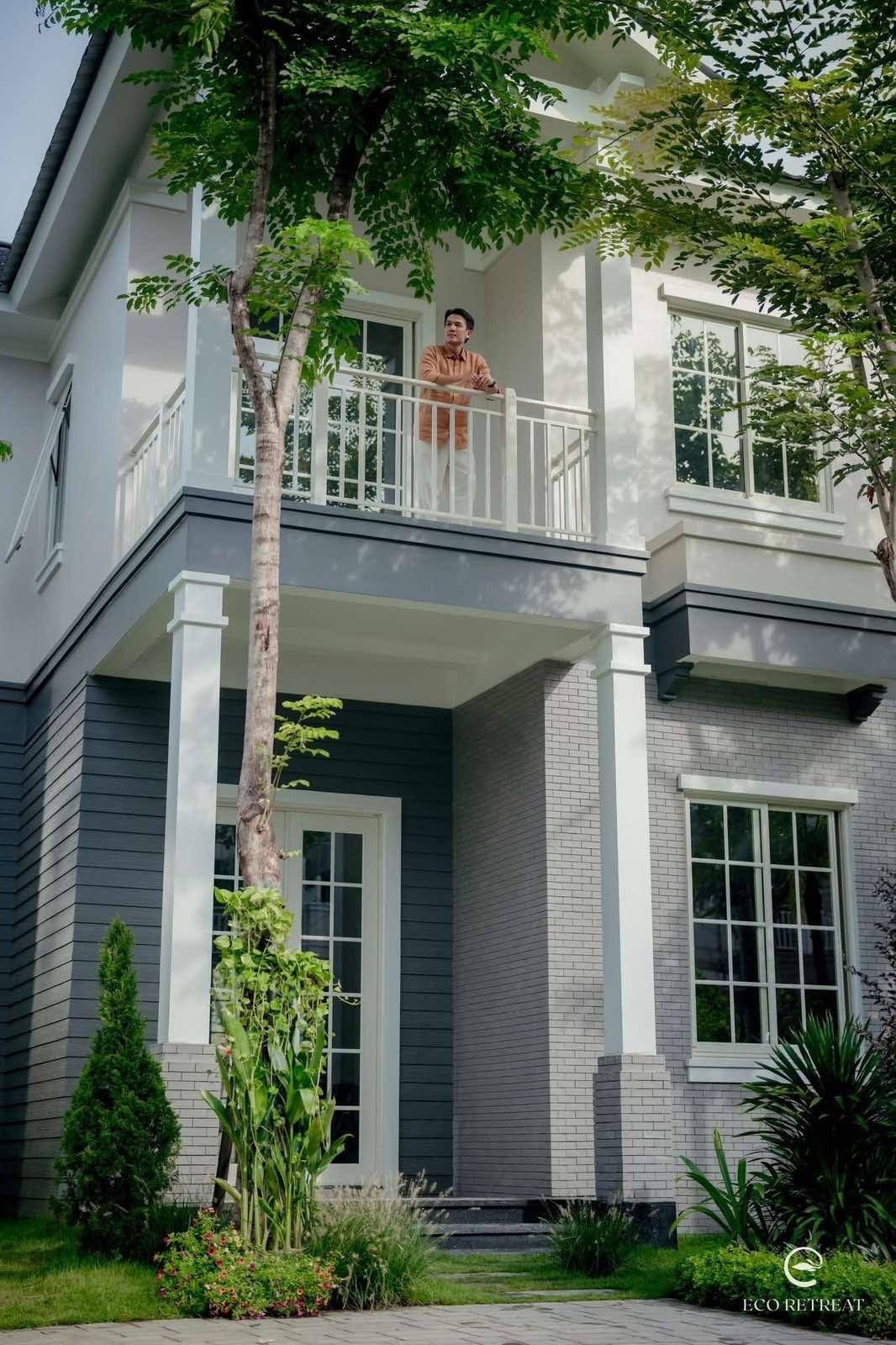 Ngôi nhà hai tầng màu xám giữa hàng cây tại Home Retreat