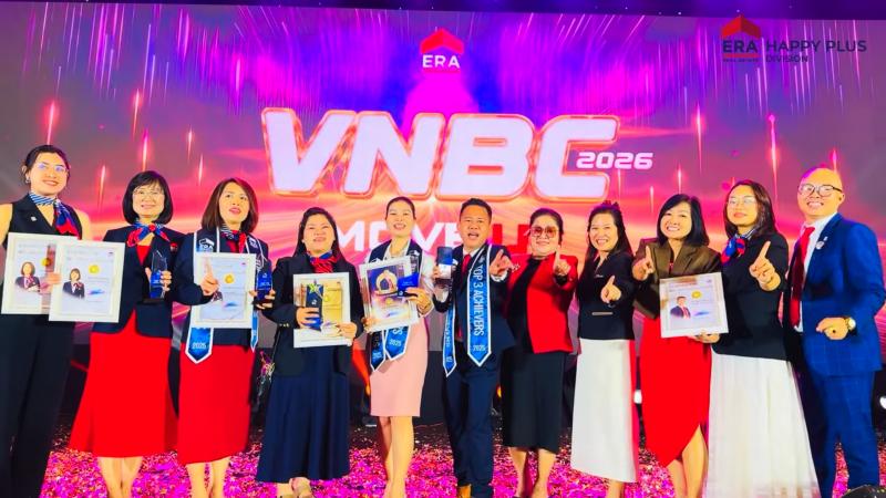 Đội ngũ Happy Plus chụp ảnh cùng bằng khen trước sân khấu VNBC 2026