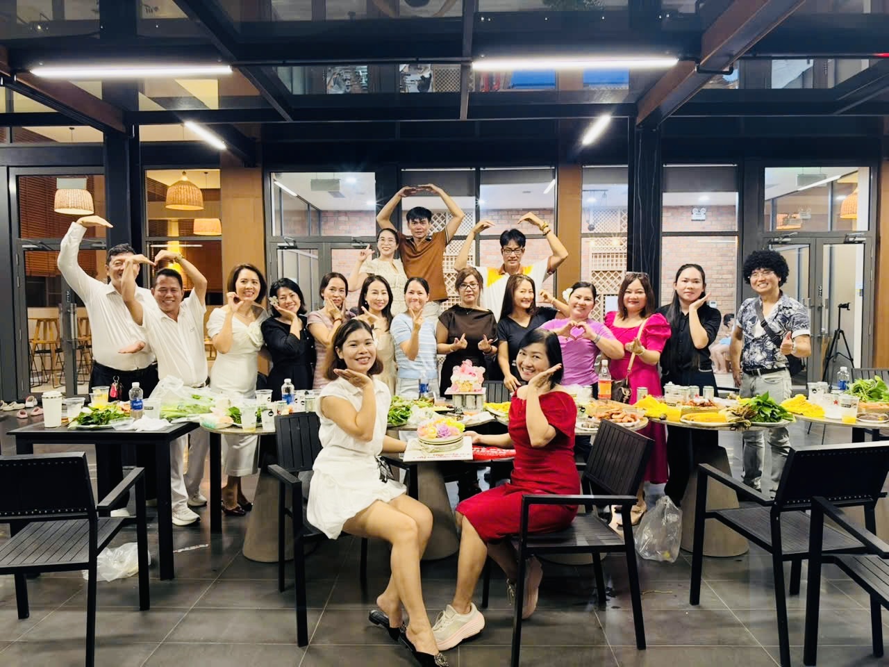 Cả team Happy Plus tạo hình trái tim bên bàn tiệc và bánh kem