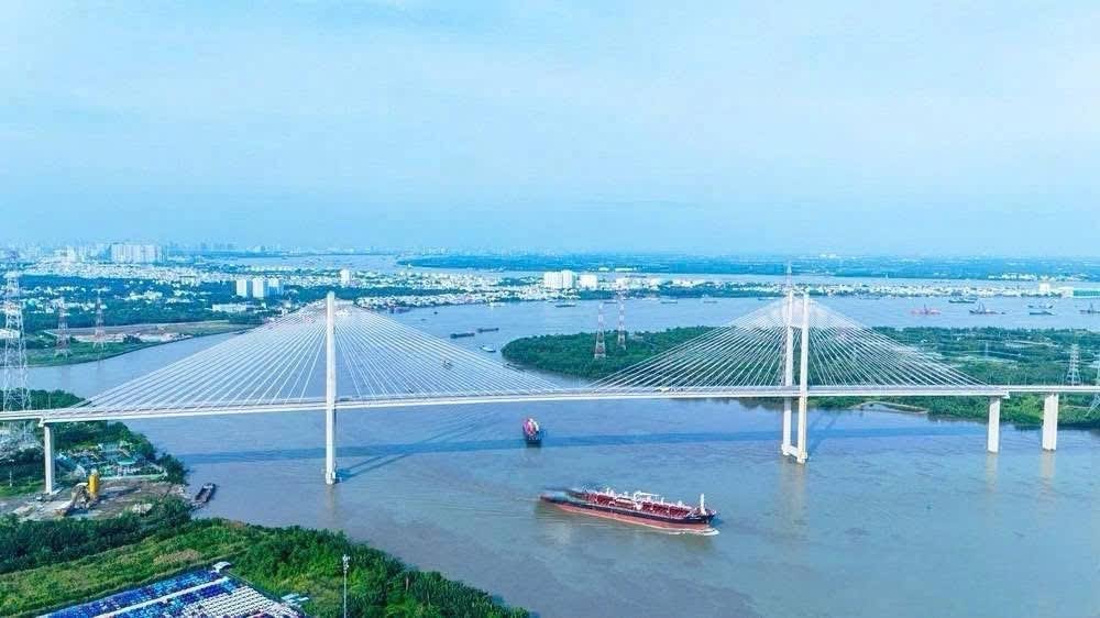 Cầu Bình Khánh vượt sông Soài Rạp nhìn từ trên cao, tàu chở hàng đi qua bên dưới nhịp chính